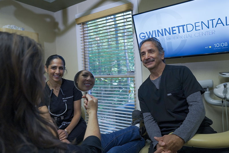 Dr. Nisha Kancherla and doctor giving patient a mirror